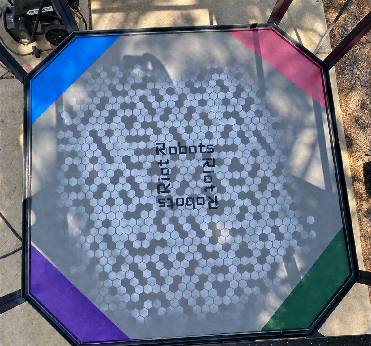 Top-down view of the finished Riot Robots arena floor with custom graphics