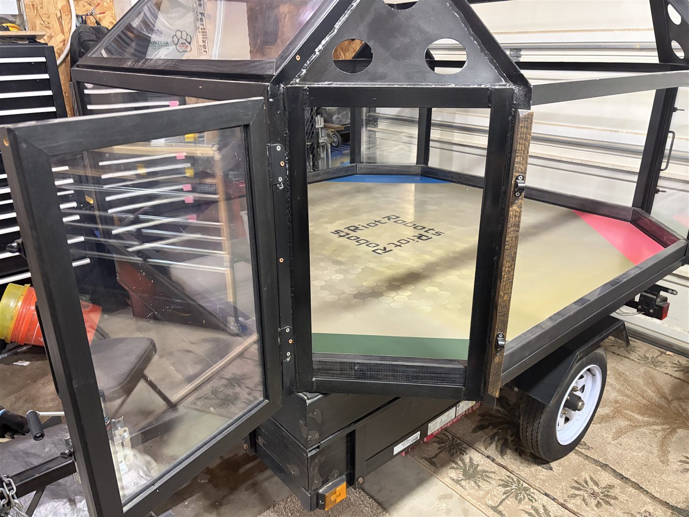 A fitted arena access door open on the trailer-mounted enclosure